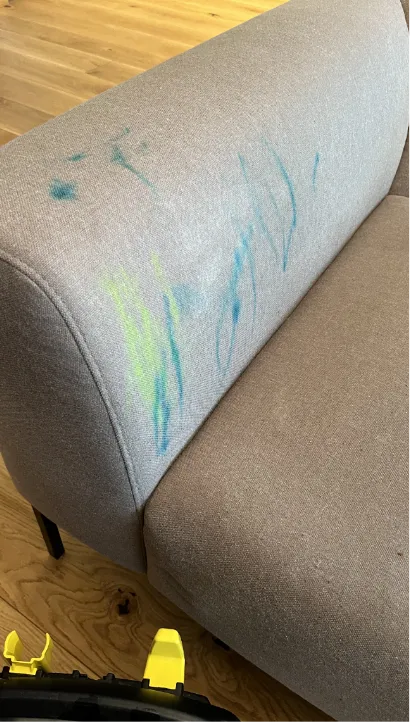 Sinised ja rohelised vildikajooned heleda diivani käetoel